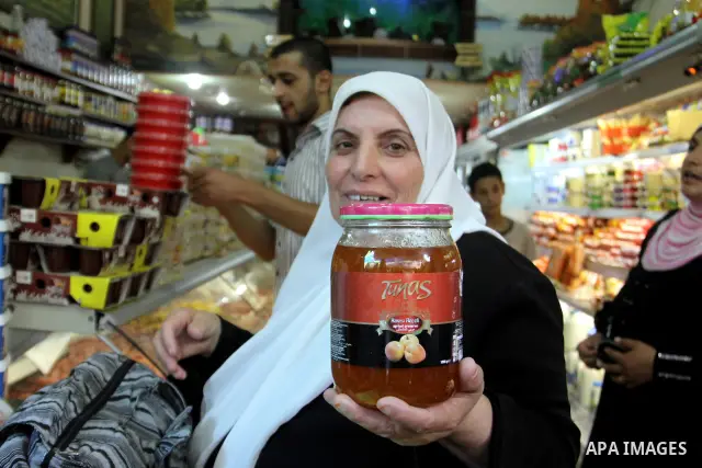 A Palestinian woman shows foodstuff in a shop in preparation for the holy month of Ramadan in the West Bank city of Nablus, on July 19, 2012 . Islam's holy month of Ramadan will begin in two days depending on the sightin...
