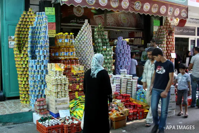 Palestinians buy foodstuff from a shop in preparation for the holy month of Ramadan in the West Bank city of Nablus, on July 19, 2012 . Islam's holy month of Ramadan will begin in two days depending on the sighting of th...