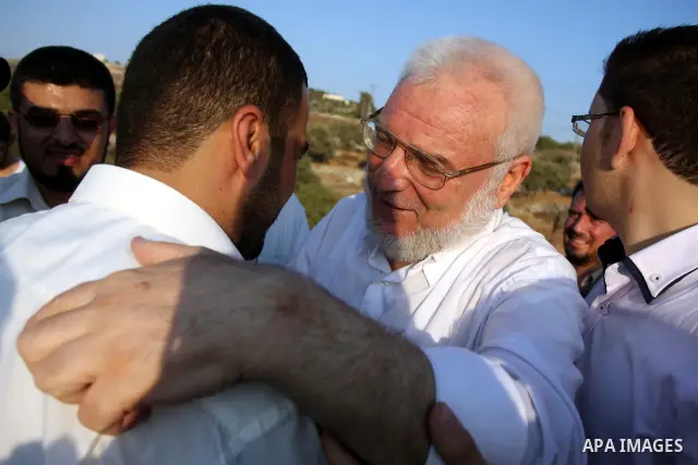 Hamas speaker of the Palestinian parliament Aziz Dweik embraces his family after he was released from Israeli prison, at the Beit Sira roadblock in the West Bank on 19 July 2012. The Israeli army arrested Dweik on Januar...
