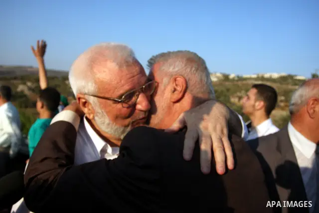 Hamas speaker of the Palestinian parliament Aziz Dweik embraces his family after he was released from Israeli prison, at the Beit Sira roadblock in the West Bank on 19 July 2012. The Israeli army arrested Dweik on Januar...