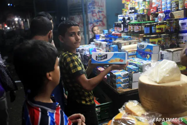 Palestinians Inspect goods as the vendor displays it in preparation for the holy month of Ramadan in the Gaza city on July 19, 2012 .Ramadan is the ninth month of the Islamic calender, a month of fasting, in which partic...