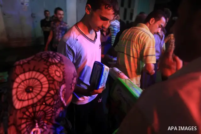 Palestinians Inspect goods as the vendor displays it in preparation for the holy month of Ramadan in the Gaza city on July 19, 2012 .Ramadan is the ninth month of the Islamic calender, a month of fasting, in which partic...
