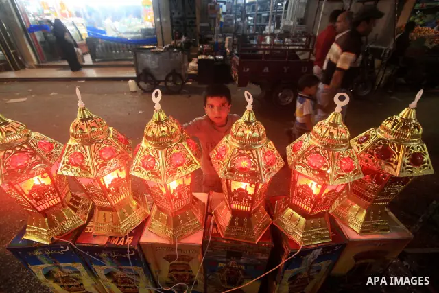 A Palestinian child Inspects toys and electric lights as the vendor displays goods in preparation for the holy month of Ramadan in the Gaza city on July 19, 2012. Ramadan is the ninth month of the Islamic calender, a mon...