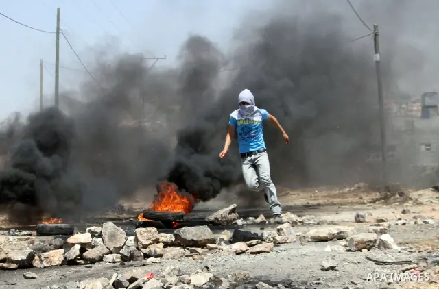 A Palestinian protestor throws stones at Israeli troops during clashes as they protest against the Jewish settlement of Kdumim, near Nablus, West Bank, 20 July 2012. According to medical sources 16 Palestinians were inju...