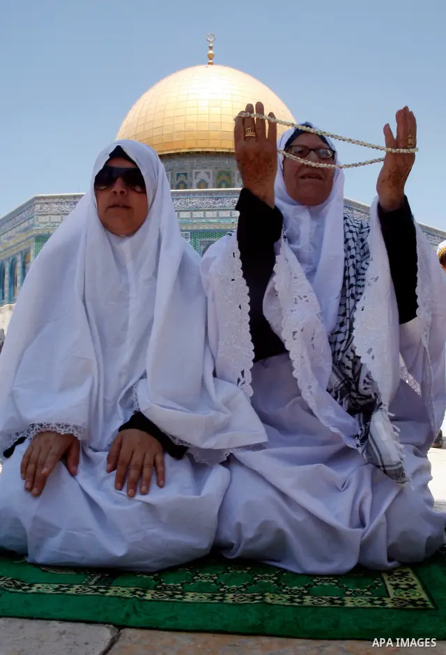 Palestinian women pray outside the Dome of the Rock on the compound known to Muslims as Noble Sanctuary and to Jews as Temple Mount in Jerusalem's Old City on the first Friday of the holy month of Ramadan July 20, 2012....