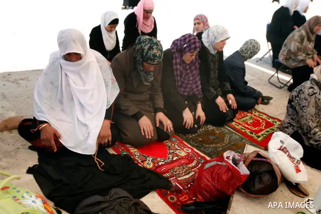Palestinian women pray outside the Dome of the Rock on the compound known to Muslims as Noble Sanctuary and to Jews as Temple Mount in Jerusalem's Old City on the first Friday of the holy month of Ramadan July 20, 2012....