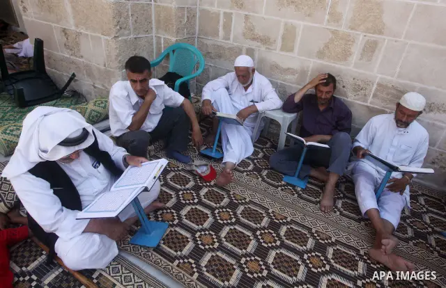 Palestinian muslims read the holy Qur'an at al-Omari mosque in Gaza city, on 21 July 2012. Muslims around the world refrain from eating, drinking and sexual intercourse from dawn till dusk during Ramadan, the holiest mon...