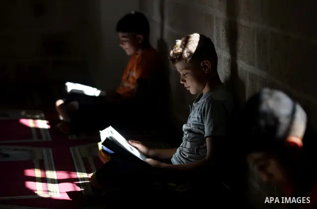 Palestinian children read the holy Qur'an at a mosque in Gaza city, on 21 July 2012. Muslims around the world refrain from eating, drinking and sexual intercourse from dawn till dusk during Ramadan, the holiest month in...