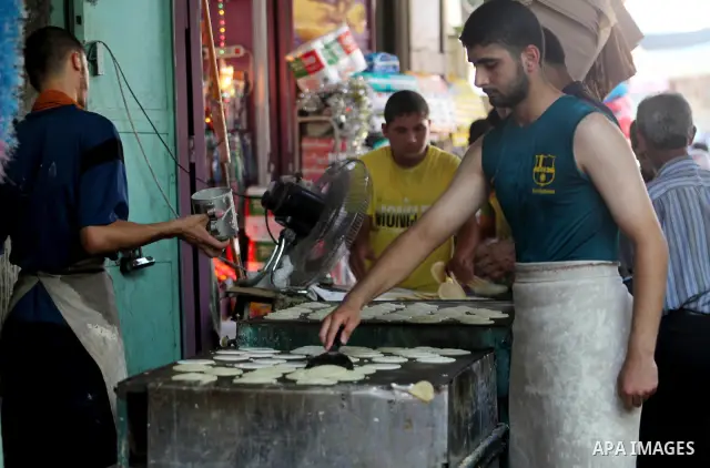 A Palestinian vendor prepares a traditional pancake known as "Qatayef" on the second day of the holy month of Ramadan, at a shop in Gaza City, on 21 July 2012. Muslims around the world abstain from eating, drinking and c...
