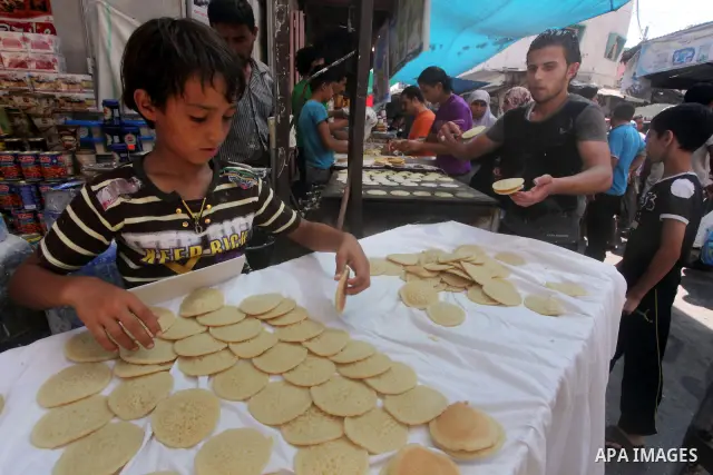 A Palestinian vendor prepares a traditional pancake known as "Qatayef" on the second day of the holy month of Ramadan, at a shop in Gaza City, on 21 July 2012. Muslims around the world abstain from eating, drinking and c...