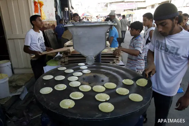 A Palestinian vendor prepares a traditional pancake known as "Qatayef" on the second day of the holy month of Ramadan, at a shop in Rafah in south of Gaza Strip, on 21 July 2012. Muslims around the world abstain from eat...