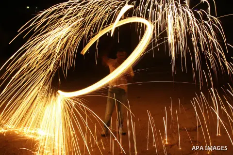 A Palestinian man lights fireworks to celebrate the second day of the Muslim Holy fasting month of Ramadan in the West bank city of Nablus on 21 July 2012. Muslims throughout the world are celebrating the fasting month o...