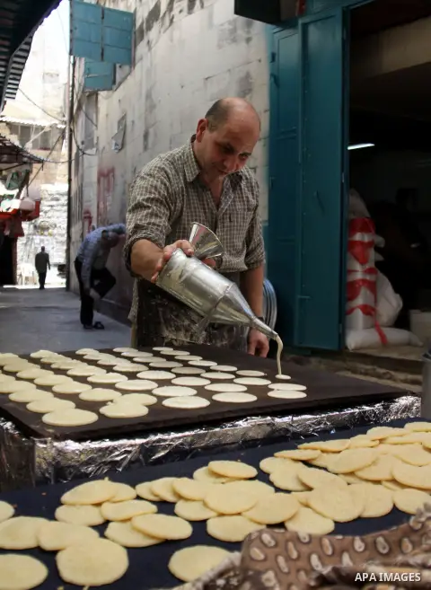A Palestinian sweet-maker prepares traditional pancake known as "Qatayef" consumed during Ramadan in the West Bank city of Nablus, on July 22, 2012. Muslims around the world abstain from eating, drinking and conducting s...