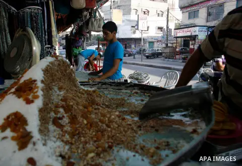 A Palestinian man prepares traditional pancake known as "Qatayef" consumed during Ramadan in Rafah in the south of Gaza strip, on July 22, 2012. Muslims around the world abstain from eating, drinking and conducting sexua...