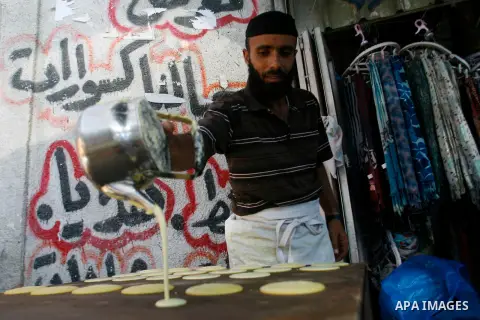 A Palestinian man prepares traditional pancake known as "Qatayef" consumed during Ramadan in Rafah in the south of Gaza strip, on July 22, 2012. Muslims around the world abstain from eating, drinking and conducting sexua...