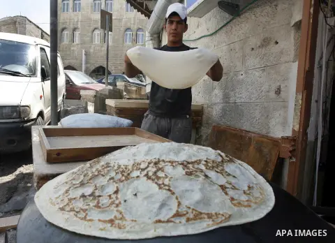 A Palestinian vendor bakes traditional bread during Ramadan in Jerusalem's old city, on July 23, 2012. Muslims around the world abstain from eating, drinking and conducting sexual relations from dawn till dusk during Ram...