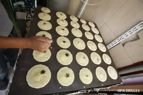A Palestinian man prepares traditional pancake known as "Qatayef" consumed during Ramadan in Jerusalem's old city, on July 23, 2012. Muslims around the world abstain from eating, drinking and conducting sexual relations...