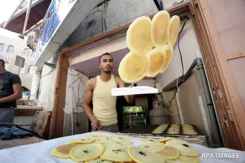 A Palestinian man prepares traditional pancake known as "Qatayef" consumed during Ramadan in Jerusalem's old city, on July 23, 2012. Muslims around the world abstain from eating, drinking and conducting sexual relations...