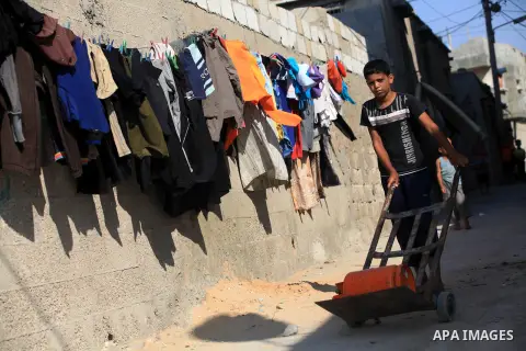 A Palestinian child fills canisters with cooking gas in the Beach refugee camp in Gaza City before Breaking fast on the third day of the Holy month of Ramadan, in Gaza Strip, 24 July 2012. Muslims throughout the world ar...