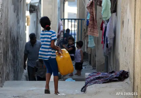A Palestinian child fills jerry cans of water in the Beach refugee camp in Gaza City before Breaking fast on the third day of the Holy month of Ramadan, in Gaza Strip, 24 July 2012. Muslims throughout the world are celeb...