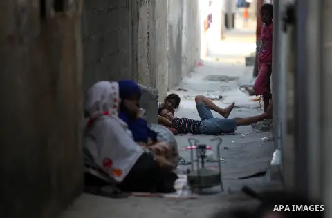 A Palestinian woman prepares food for the fast-breaking meal in front of her home in the Beach refugee camp in Gaza City before Breaking fast on the third day of the Holy month of Ramadan, in Gaza Strip, 24 July 2012. Mu...