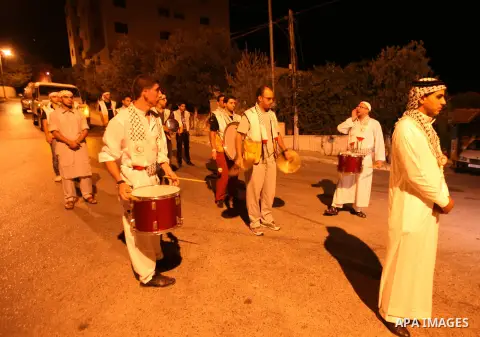 Palestinian youths volunteer of Red Crescent use a traditional drum to wake up people for their Suhoor in a narrow street in the West Bank City of Hebron on July 26, 2012. Photo by Mamoun Wazwazi