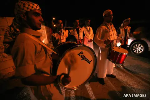 Palestinian youths volunteer of Red Crescent use a traditional drum to wake up people for their Suhoor in a narrow street in the West Bank City of Hebron on July 26, 2012. Photo by Mamoun Wazwazi