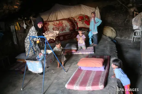 A Palestinian woman looks after her children in a cave, where they live, near the Palestinian village of Jimba, south of Yatta, near the West Bank town of Hebron on July 25, 2012. The Israeli Defence Minister, Ehud Barak...