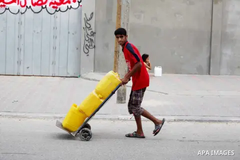 A Palestinian child carry potable water bottles filled on a cart near a water purification station, in Deir al-Balah central Gaza Strip, on July 11. 2012. Palestinians suffer from the severe lack of potable water during...