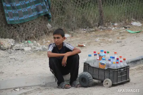 A Palestinian child waits near a water purification station to fill his bottles a potable water, in Deir al-Balah central Gaza Strip, on July 11. 2012. Palestinians suffer from the severe lack of potable water during the...