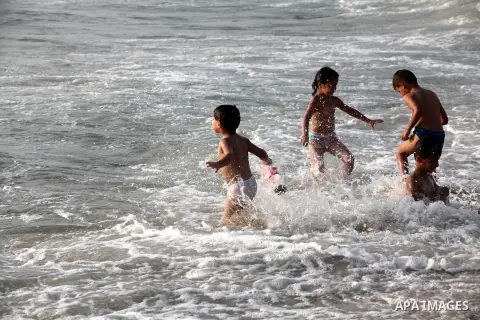 Palestinian children enjoy swimming at Gaza beach during the fasting holy month of Ramadan, in Gaza city on 26 July 2012. Photo by Majdi Fathi