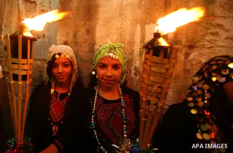 Palestinian girls hold torches in Jerusalem's Old City during celebrations to mark the breaking of the fast on the seventh day of the holy month of Ramadan, on July 26, 2012. Photo by Mahfouz Abu Turk