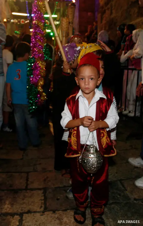 Palestinian children hold torches in Jerusalem's Old City during celebrations to mark the breaking of the fast on the seventh day of the holy month of Ramadan, on July 26, 2012. Photo by Mahfouz Abu Turk