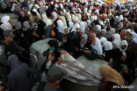 Palestinian women wait to show their identity cards to Israeli security officers at Qalandiya checkpoint outside the West Bank city of Ramallah July 27, 2012, as they make their way to Jerusalem on the second Friday of t...