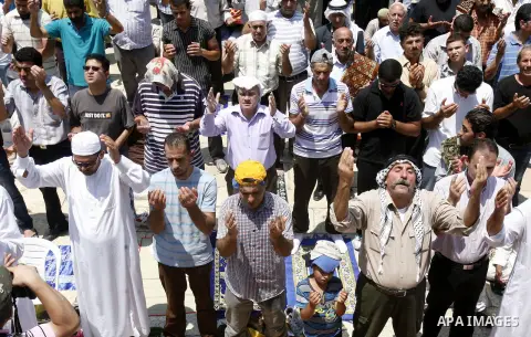 Palestinian worshippers pray outside al-Aqsa mosque in Jerusalem's Old City on the Second Friday of the holy month of Ramadan July 27, 2012. Israeli police said that Palestinian over the age of 40 would be freely permitt...