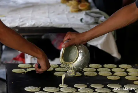 A Palestinian man prepares traditional pancake known as ''Qatayef'' consumed during the fasting month of Ramadan in Rafah refugee camp southern Gaza strip, on July 27, 2012. Muslims around the world abstain from eating,...
