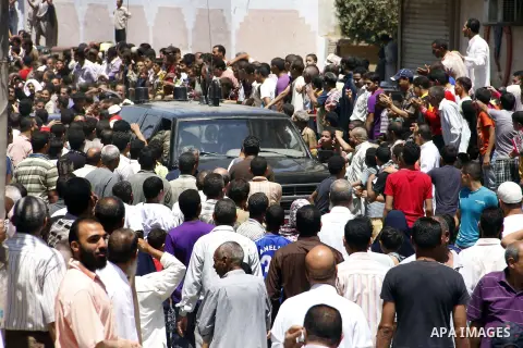 Egypt's President Mohamed Mursi (not pictured) gather outside a mosque where Mursi will be taking part in Friday prayers during the Islamic holy month of Ramadan in Fayoum, about 100 km (60 miles) southeast of Cairo, Jul...