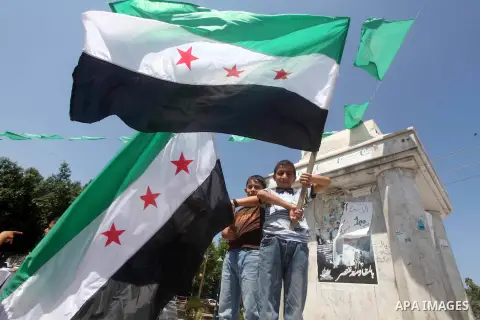 Palestinian children hold a Syrian revolution flag during a protest against Syria's President Bashar al-Assad and support of Syrian Children at the Al joundi Al Majhoul in Gaza City on July 28, 2012. Photo by Ashraf Amra