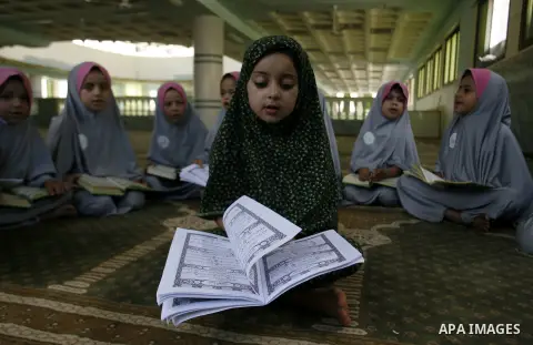 Palestinian girls read the holy Qur'an at mosque in Rafah in southern Gaza strip, on 29 July 2012. Muslims around the world refrain from eating, drinking and sexual intercourse from dawn till dusk during Ramadan, the hol...
