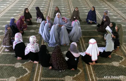 Palestinian girls read the holy Qur'an at mosque in Rafah in southern Gaza strip, on 29 July 2012. Muslims around the world refrain from eating, drinking and sexual intercourse from dawn till dusk during Ramadan, the hol...