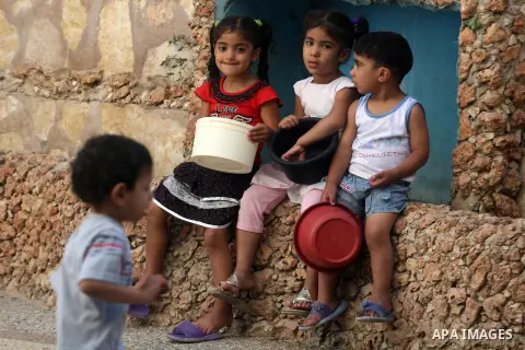 Palestinian indigent children wait to recieve food from volunteers during the fasting month of Ramadan in Jerusalem on July 28, 2012. During Ramadan eating, drinking, sex and smoking is banned and restaurants are forbidd...