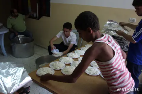 Palestinian indigent Muslims recieve food from volunteers during the fasting month of Ramadan in In the West Bank, Al-Amari refugee camp near Ramallah July 29, 2012. During Ramadan eating, drinking, sex and smoking is ba...