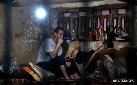 Palestinian inmates sit inside their cell during the holy month of Ramadan at prison controlled by the Hamas police in Gaza city on 29 July 2012. Hamas police released more than 150 criminal inmates before the fasting mo...