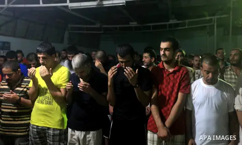 Palestinian inmates participate a prayer during the holy month of Ramadan at prison controlled by the Hamas police in Gaza city on 29 July 2012. Hamas police released more than 150 criminal inmates before the fasting mon...