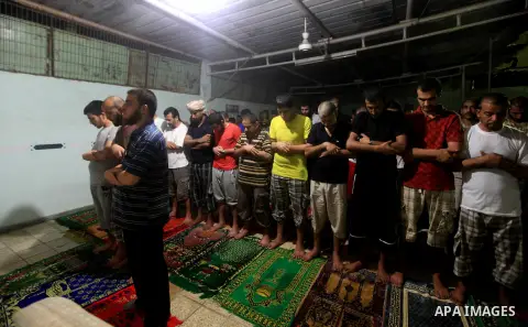 Palestinian inmates participate a prayer during the holy month of Ramadan at prison controlled by the Hamas police in Gaza city on 29 July 2012. Hamas police released more than 150 criminal inmates before the fasting mon...