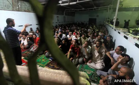Palestinian inmates participate a prayer during the holy month of Ramadan at prison controlled by the Hamas police in Gaza city on 29 July 2012. Hamas police released more than 150 criminal inmates before the fasting mon...