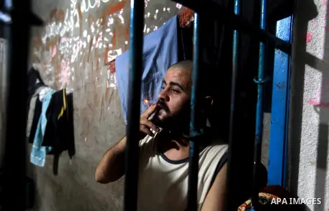 A Palestinian inmate smoke a cigarette inside his cell after breaking his fast during the holy month of Ramadan at prison controlled by the Hamas police in Gaza city on 29 July 2012. Hamas police released more than 150 c...
