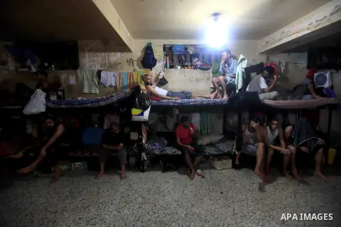 Palestinian inmates sit inside their cell during the holy month of Ramadan at prison controlled by the Hamas police in Gaza city on 29 July 2012. Hamas police released more than 150 criminal inmates before the fasting mo...