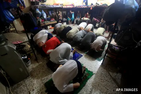 Palestinian inmates participate a prayer during the holy month of Ramadan at prison controlled by the Hamas police in Gaza city on 29 July 2012. Hamas police released more than 150 criminal inmates before the fasting mon...