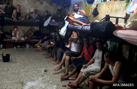 Palestinian inmates sit inside their cell during the holy month of Ramadan at prison controlled by the Hamas police in Gaza city on 29 July 2012. Hamas police released more than 150 criminal inmates before the fasting mo...